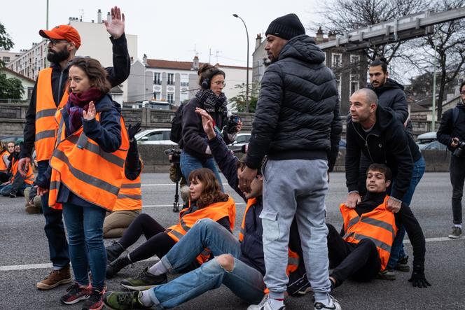 Members of a recent renovation collective block cars on the ring road in Port d'Ivre, Paris on November 11, 2022. 
