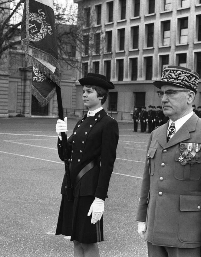 Anne Chopinet, première femme admise à l'école Polytechnique, au côté du général Briquet, directeur de l'X, lors de la cérémonie de présentation de la promotion 73 dans la cour de l'établissement, le 16 mars 1974.