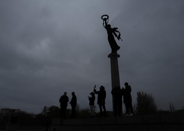 At the foot of the monument to the Unknown Soldier, near the Slavy park, Ukrainians try to get cell phone coverage from a Russian network facing the left bank of the Dnieper