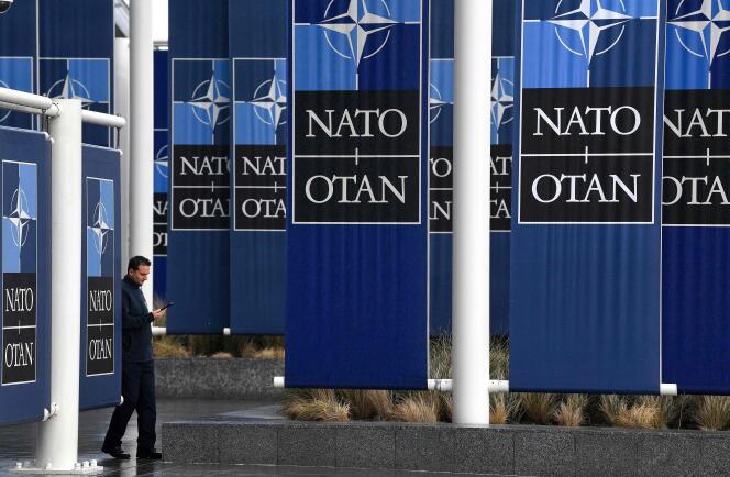 A man walks past  the banners of the North Atlantic Treaty Organisation (NATO) at its headquarters in Brussels on November 16, 2022. 