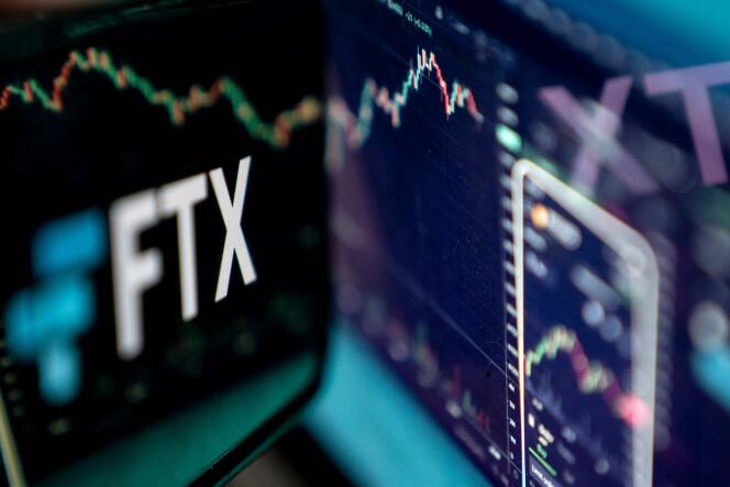 Sur cette photo d'illustration prise le dimanche 13 novembre 2022, le logo de la plateforme de crypto-monnaie FTX s'affiche sur un écran avec le site internet du groupe en arrière-plan. 