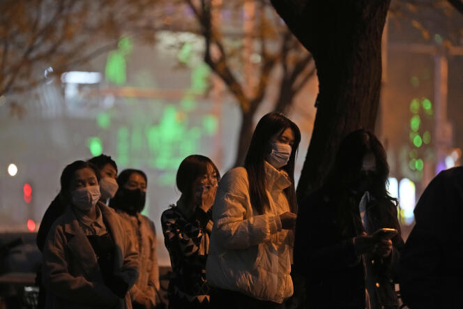 Des résidents font la queue pour effectuer des tests de Covid-19 dans une rue de Pékin, dimanche 20 novembre 2022, alors que de nouvelles mesures strictes sont imposées à Pékin.