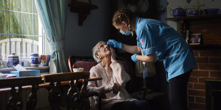Be Caring carer Toni Kirlew applies eye drops for client Margaret Worsnop in the clients home in Leeds, England.