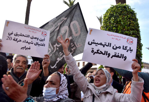Moroccans raise placards as they gather in front of parliament in the capital Rabat to protest against rising prices, on February 20, 2022. (Photo by AFP)
