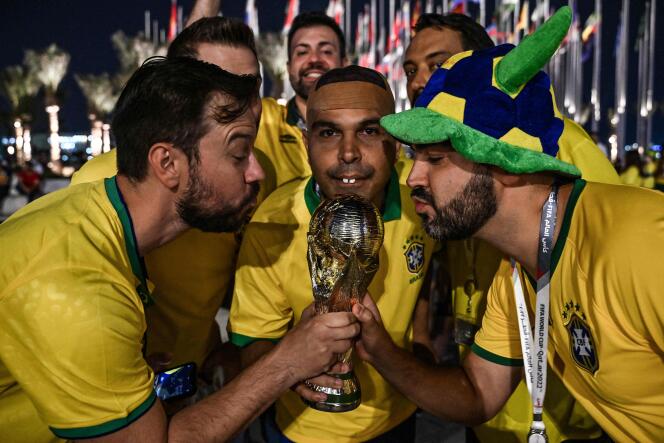 A group of Brazilian supporters pose with a replica of the World Cup in Doha on November 22. 