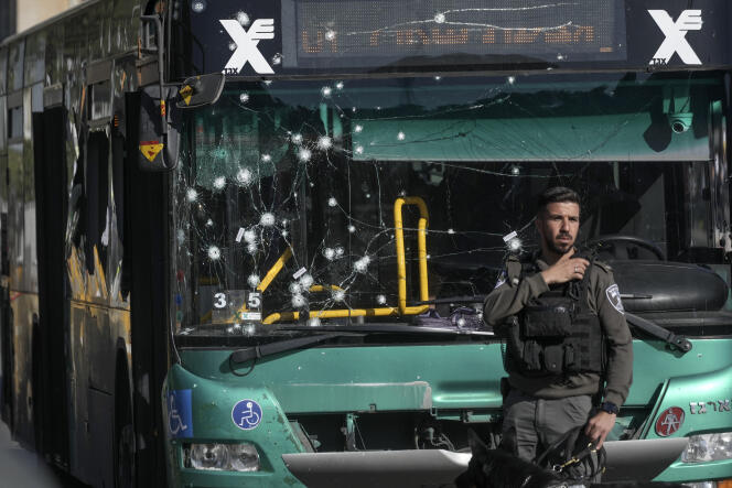 An Israeli policeman examines the scene of one of two bombings at bus stops in Jerusalem on November 23, 2022. 