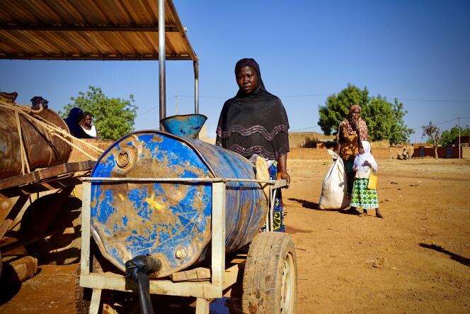 Le 9 novembre 2022, Awa Sawadogo pousse sa citerne de 200 litres, à Ouahigouya, dans le nord du Burkina Faso. Pour assurer les besoins de sa famille, elle doit faire cette corvée matin et soir.