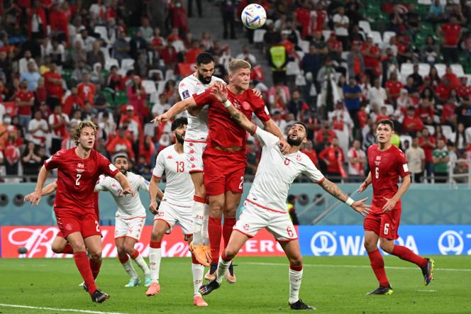 L’attaquant danois Andreas Cornelius au duel avec deux défenseurs tunisiens au stade Education City à Al-Rayyan (Qatar), le 22 novembre 2022.