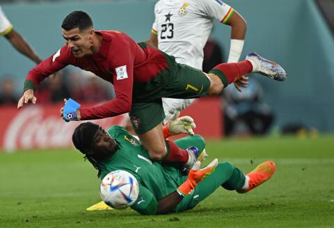 TOPSHOT - Portugal's forward #07 Cristiano Ronaldo collides with Ghana's goalkeeper #01 Lawrence Ati Zigi during the Qatar 2022 World Cup Group H football match between Portugal and Ghana at Stadium 974 in Doha on November 24, 2022. (Photo by MANAN VATSYAYANA / AFP)