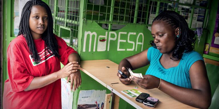 Lisa Wanjiru makes a cash payment to M-Pesa agent Jane Njuguna at a M-Pesa kiosk in South B, a residential area of the city. M-Pesa, (M for mobile, pesa is Swahili for money), is a Kenyan cellphone-based money transfer service. The majority of its customers have no bank accounts, but they withdraw cash and make payments or send money using their cell phones. A network of appointed agents, scattered all over the country, provide the cashing handling services. 
 *** Local Caption *** 
Africa micro-finance economics business money women telecommunications technology