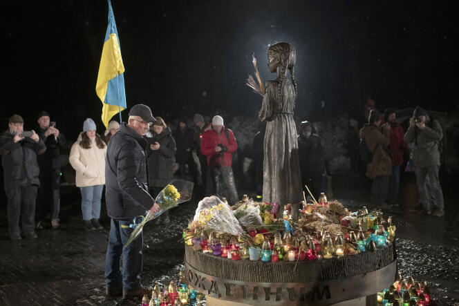 La gente enciende velas y pone flores frente al monumento en honor a las víctimas del Holodomor, en Kiev, Ucrania, el 26 de noviembre de 2022. El término Holodomor, que en ucraniano significa 