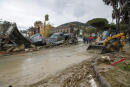 Rescuers remove mud from a street after heavy rainfall triggered landslides that collapsed buildings and left as many as 12 people missing, in Casamicciola, on the southern Italian island of Ischia, Italy, Saturday, Nov. 26, 2022. Firefighters are working on rescue efforts as reinforcements are being sent from nearby Naples, but are encountering difficulties in reaching the island either by motorboat or helicopter due to the weather. (AP Photo/Salvatore Laporta)