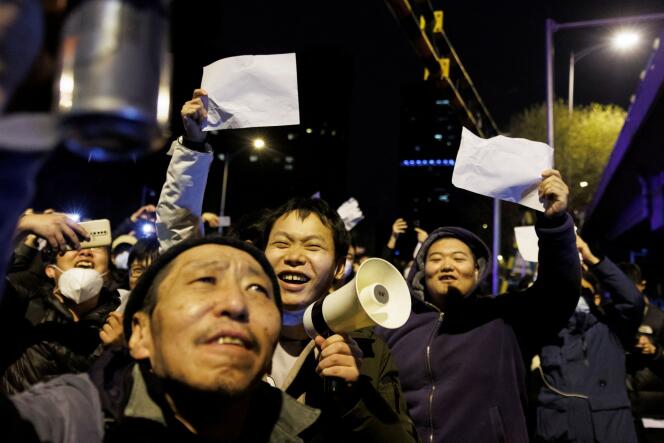 Demonstrators hold up white papers against coronavirus restrictions in Beijing on November 28, 2022.
