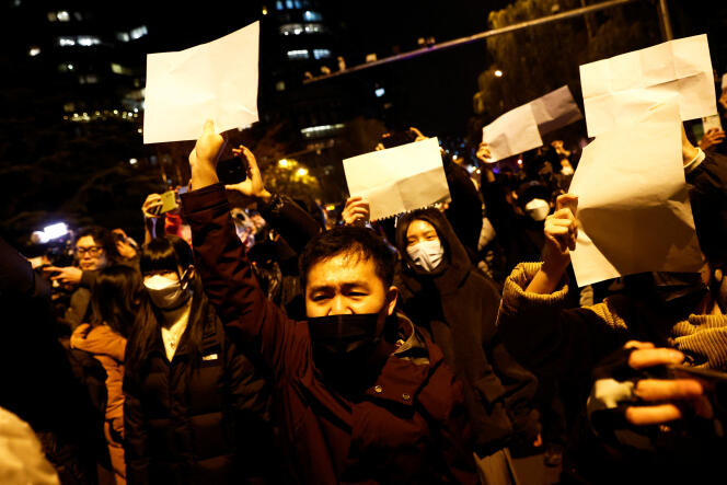 Protestestation avec des feuilles blanches contre les restrictions liées à la maladie du coronavirus (COVID-19), lors d’un hommage aux victimes d’un incendie, à Urumqi, en Chine, le 27 novembre 2022. 