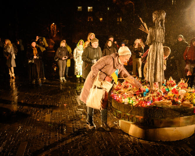 Le 26 novembre 2022, à Kiev, des personnes dépose des fleurs lors d’une cérémonie au monument des victimes de l’Holodomor, terme ukrainien signifiant « mort par famine ».
