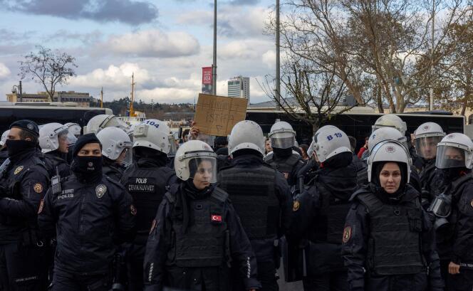 Les forces de sécurité encerclent un manifestant tenant une pancarte indiquant « Gouvernement démissionne » à Istanbul, en Turquie, le 27 novembre 2022.