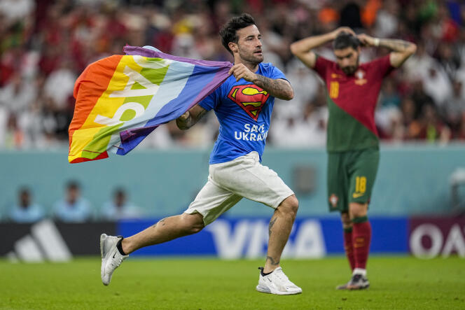 Un supporteur s’immisce sur le terrain durant le match entre le Portugal et l’Uruguay et brandit un drapeau arc-en-ciel symbole de paix, au stade de Lusail, au Qatar, lundi 28 novembre 2022.