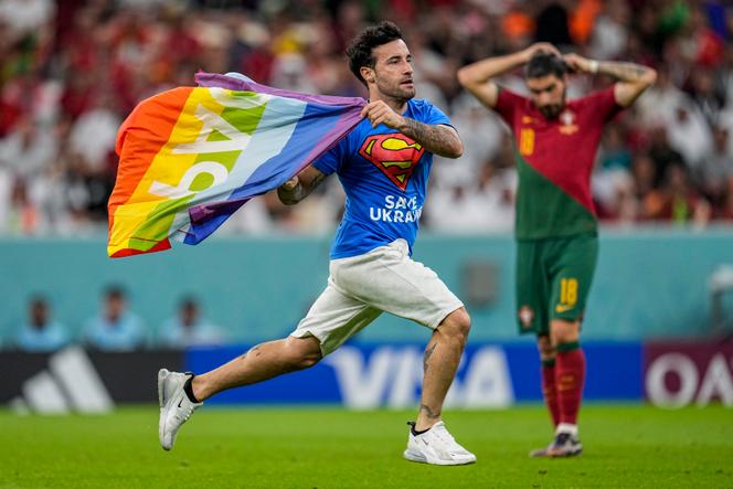 Un supporteur s’immisce sur le terrain durant le match entre le Portugal et l’Uruguay et brandit le drapeau arc-en-ciel LGBT, au stade de Lusail, au Qatar, lundi 28 novembre 2022.