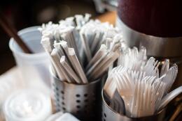 Plastic straws wrapped in paper and plastic forks are seen at a food hall in Washington DC on June 20, 2019. - "How do you drink a milkshake without a straw?" The city of Washington has decided, in the name of the environment, to ban plastic drinking straws -- an act viewed as almost sacrilegious in the birthplace of this simple but seemingly indispensable part of daily American life.In the last century, millions of straws were produced in the Stone Straw Building, a stolid-looking structure of yellowing brick in a residential neighborhood. The building now houses the capital's transit police headquarters. The only visible sign of its historic character comes from a discreet commemorative plaque affixed to a wall above a garbage bin that honors the memory of Marvin C. Stone, "Inventor of the Paper Straw." (Photo by Eric BARADAT / AFP)