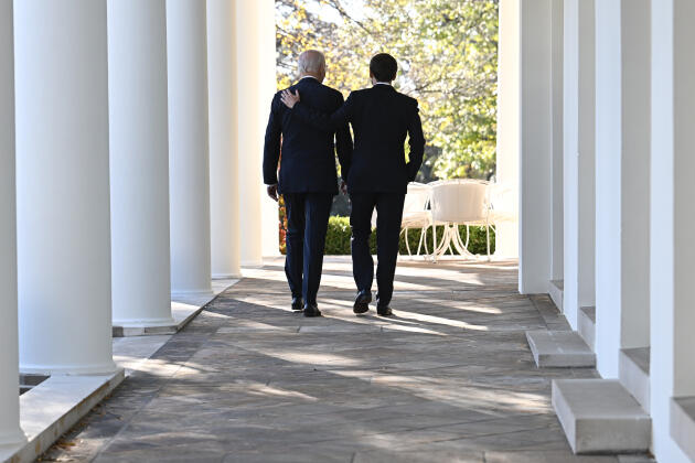 President Joe Biden and French President Emmanuel Macron walk along the Colonnade of the White House.