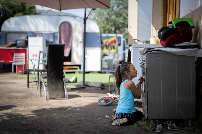 Une petite fille se maquille à l’aide de la vitre d’une cuisinière, dans un campement de Roumains majoritairement roms, près de Nantes, le 21 juin 2022.
