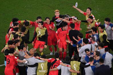 South Korea's players celebrate qualifying for the World Cup last 16 at Uruguay's expense during the Qatar 2022 World Cup Group H football match between South Korea and Portugal at the Education City Stadium in Al-Rayyan, west of Doha on December 2, 2022. (Photo by Kirill KUDRYAVTSEV / AFP)