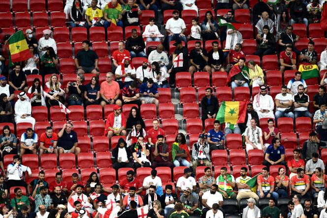 Des supporteurs et des sièges vides avant le match Angleterre-Sénégal comptant pour les huitièmes de finale de la Coupe du monde au stade Al-Bayt à Al-Khor, au nord de Doha, le 4 décembre 2022. 