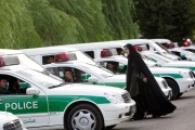 An Iranian policewoman walks between police vehicles preparing to start a crackdown to enforce Islamic dress code in  Tehran on July 23, 2007.