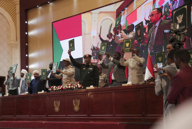 Le chef de l’armée soudanaise, le général Abdel Fattah Abdelrahman Al-Bourhane, (au centre), et des généraux brandissent un document à la suite de la signature d’un accord initial visant à mettre fin à une crise causée par le coup d’Etat militaire de 2021, à Khartoum, le lundi 5 décembre 2022.