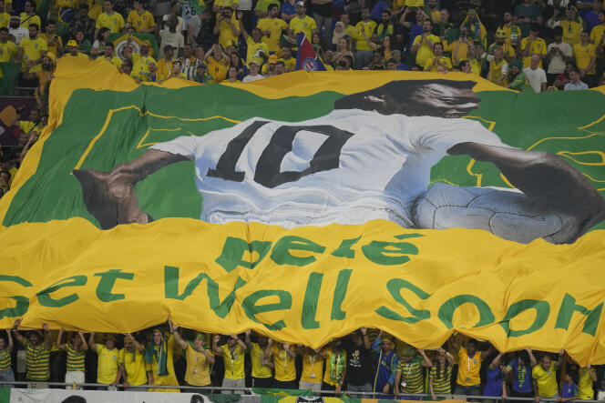 Les fans brésiliens tiennent une bannière montrant le footballeur Pelé, lors des huitièmes de finale au Qatar, le 5 décembre 2022. 