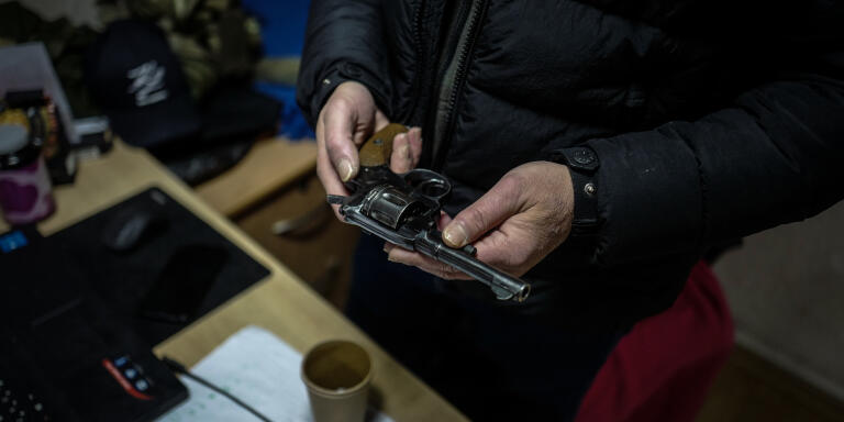 Bukovskiy Mykolay, membre du « Conseil de sécurité citoyenne » d’Odessa, vérifie son arme avant de quitter les bureaux de l’organisation, le 1er décembre 2022 en Ukraine. LUCAS BARIOULET POUR «LE MONDE».