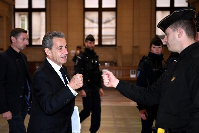 L'ancien président de la République Nicolas Sarkozy salue des gendarmes à leur arrivée au palais de justice de Paris, le 8 décembre 2022.