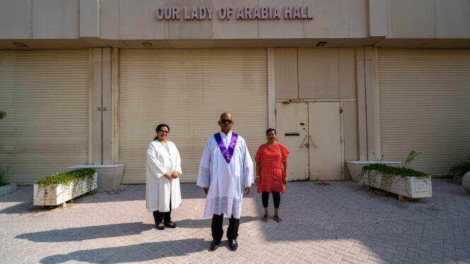 Les lectrices Joelle Marie Fernandes et Carol Mendonca, autour du prêtre Anthony Mascarenhas, devant l’église Notre-Dame-du-Rosaire à Doha (Qatar), le 7 décembre 2022.