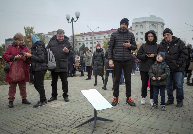 Dans le centre-ville de Kherson (Ukraine), des habitants réunis autour d’un terminal Starlink, le 12 novembre 2022.  