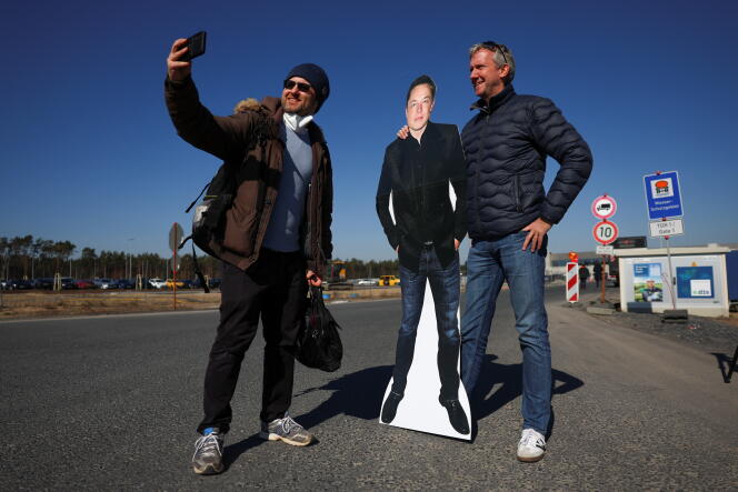Deux fans posent avec une effigie en carton d’Elon Musk, à l’extérieur de la Gigafactory de son groupe automobile Tesla, implantée à Grünheide (Allemagne), le 22 mars 2022.
