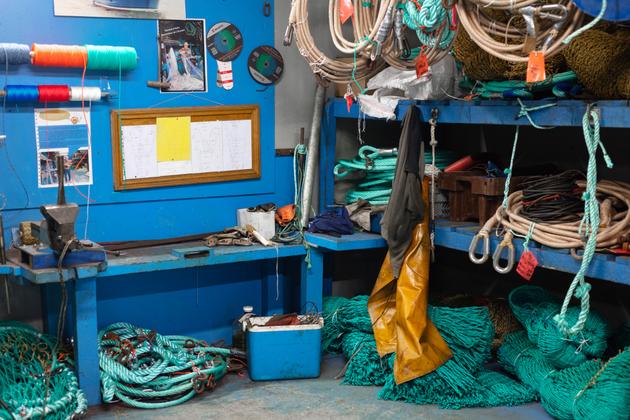 A la « seulle », l’atelier de ramendage, Alain Vicquelin répare les morceaux du chalut abîmés en mer, à Port-en-Bessin-Huppain (Calvados), le 7 décembre 2022.