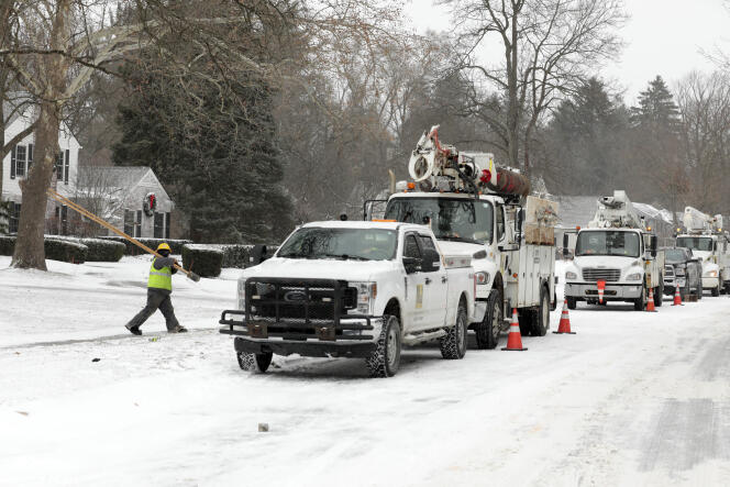 Des travailleurs des services publics rétablissent le courant à Bloomfield Hills (Michigan), le 23 décembre 2022, après la sévère tempête hivernale (− 40 °C). 