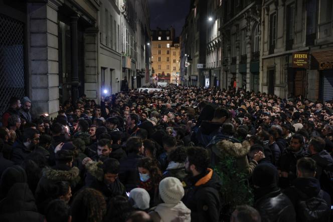 Miembros de la comunidad kurda se reúnen cerca del lugar donde tres kurdos fueron asesinados en un ataque, en el distrito 10 de París, el 23 de diciembre de 2022. 