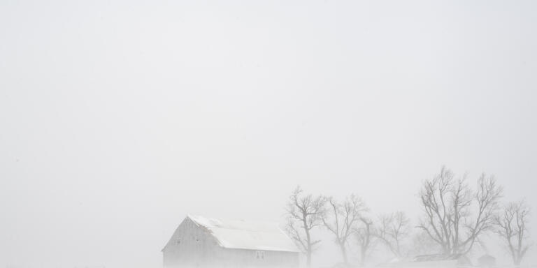 Blowing snow impairs visibility in rural Linn County, Iowa, on Friday, Dec. 23, 2022. A winter storm brought wind chill values of more than 30 degrees below zero and whiteout conditions to Eastern Iowa. (Nick Rohlman/The Gazette via AP)