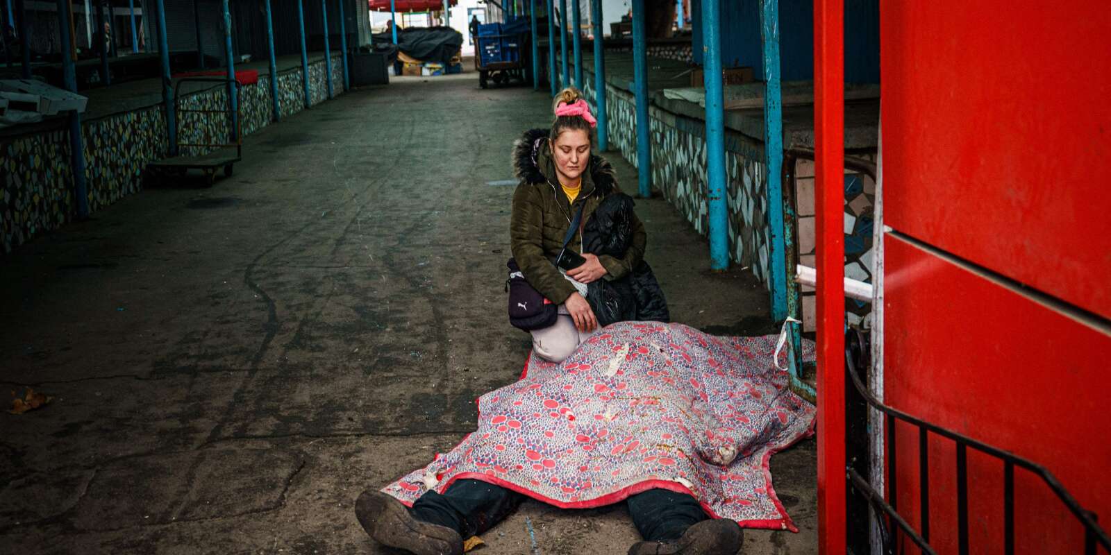 Une femme près du corps de son mari décédé après le bombardement russe sur la ville de Kherson, le 24 décembre 2022.