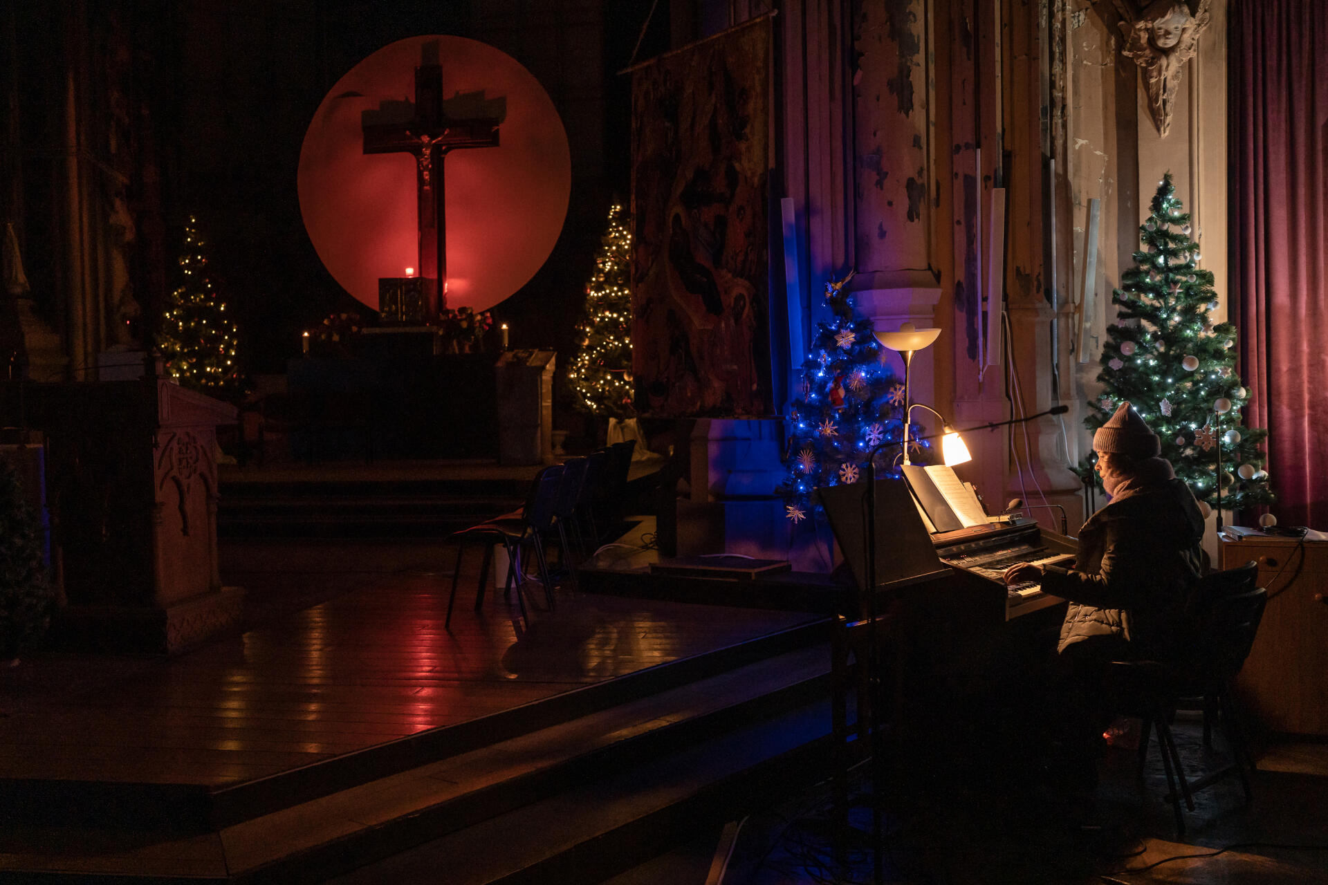 Un músico acompaña al coro en la misa de medianoche adelantada a las 19 horas debido al toque de queda, en la catedral de Saint-Mykolay, monumento que se incendió hace casi un año y medio.  En Kyiv, el 24 de diciembre de 2022. 