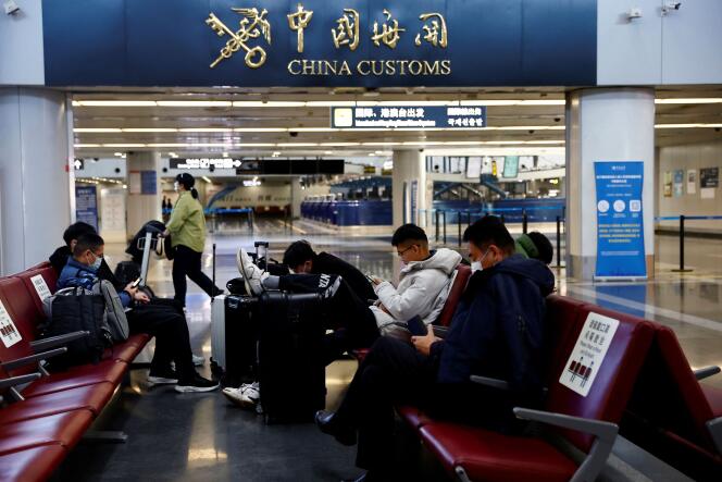 Des voyageurs attendent dans un hall de l’aéroport international de Pékin, le 27 décembre 2022. 