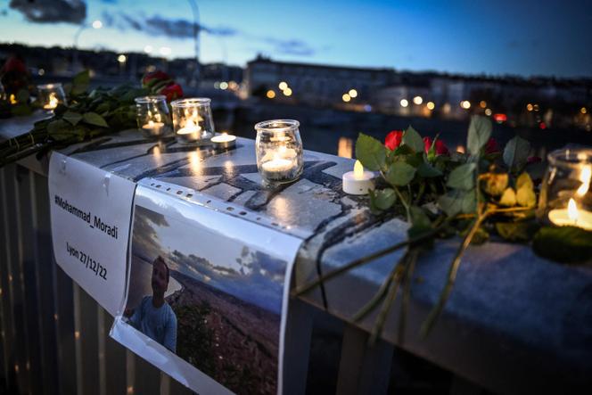 This photograph taken on in Lyon on December 27, 2022 shows candles and flowers displayed during a tribute to Mohammad Moradi, an Iranian man who killed himsel after jumping into the Rhone river to raise awareness about the situation of the Iranian people.