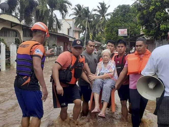 En esta foto proporcionada por la Guardia Costera de Filipinas, una mujer es transportada por guardacostas en medio de una inundación, en Plaridel, en la provincia de Misamis Occidental, en el sur de Filipinas, el 26 de diciembre de 2022.