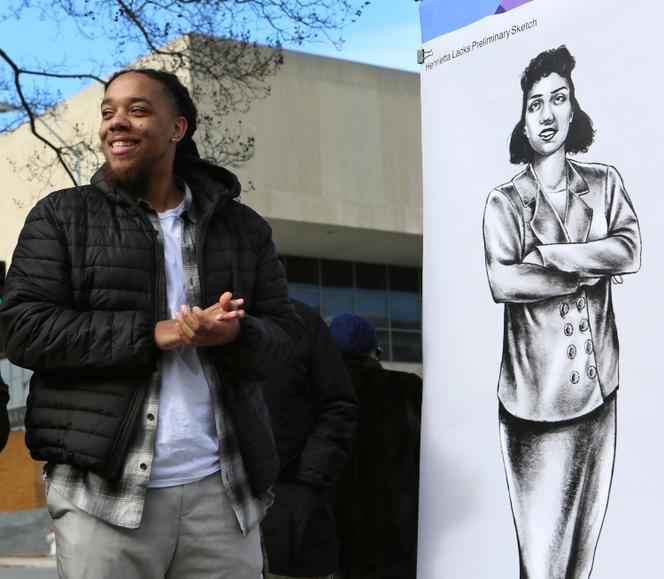 Artist Bryce Cobbs next to the portrait she drew of Henrietta Lacks which was unveiled in Roanoke, U.S., Dec. 19, 2022. The drawing will be used in the design process for a larger-than-life bronze statue. 