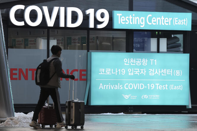 Un viajero pasa junto a carteles que indican la ubicación de un centro de pruebas de covid-19 en el Aeropuerto Internacional de Incheon, Corea del Sur, el 30 de diciembre de 2022.