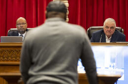 Nevada Attorney General Aaron Ford, left, and Gov. Steve Sisolak, listen to former Nevada death row inmate James Allen, speaking in favor of an incarcerated man during a pardons board meeting at the Nevada Supreme Court in Las Vegas, Tuesday, Dec. 20, 2022. (Erik Verduzco/Las Vegas Review-Journal via AP)