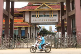 A woman rides a scooter with a child past the China-Myanmar border gate in Muse in Shan state on July 5, 2021, as the Chinese city of Ruili near the border with Myanmar imposed a lockdown and started mass testing after three Covid-19 coronavirus cases were reported on Monday. (Photo by AFP)