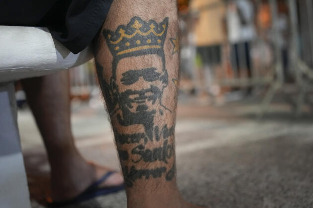 Un fan de football portant un tatouage à l’effigie de la légende du football brésilien Pelé est assis devant le stade Vila Belmiro à Santos, au Brésil, tôt le mardi 3 janvier 2023.