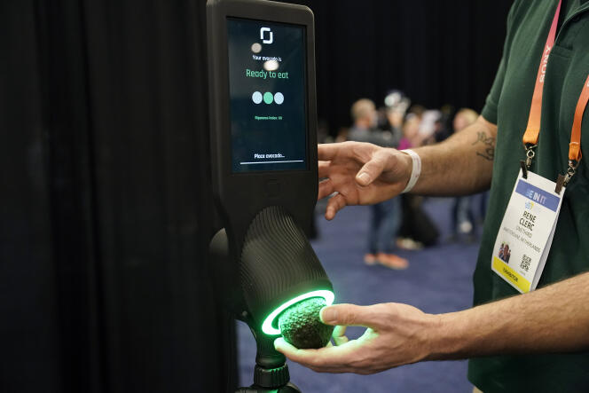 An exhibitor demonstrates the OneThird Avocado Maturity Checker, prior to the start of the consumer electronics show, Tuesday, Jan. 3, 2023, in Las Vegas, Nevada.  The device is designed to give the best moment when the avocado is ready to be eaten, without damaging it.